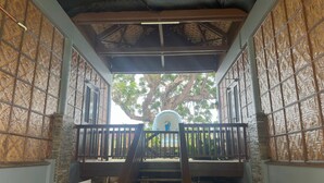 A staircase leading to a covered outdoor area with a view of a large tree and a statue. - Blue Deep Resort powered by Cocotel (Padre Burgos)