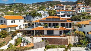 A residential area with houses featuring orange tiled roofs and solar panels. - Villa Bom Sucesso (Funchal)