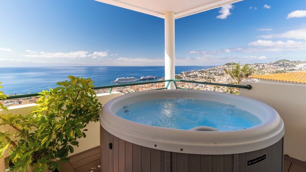 A hot tub on a balcony with a view of the sea and a cruise ship in the distance. - Villa Bom Sucesso (Funchal)