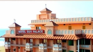 Um hotel com uma placa indicando "HOTEL SUV PALACE" e vista para a praia.