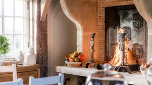 A rustic interior with a brick fireplace, a fruit basket, and a window with natural light. - Le Domaine d'Ablon (Ablon)