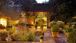 A garden with a fountain, potted plants, and a gazebo. - Le Domaine d'Ablon (Ablon)