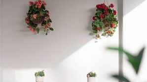 A wooden bench with two potted plants, a tiled floor, and a wall-mounted hanging plant. - Glyfada Coastside Apartment (Glyfada)