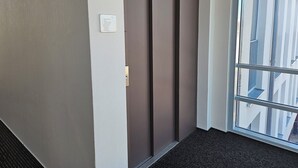 Um elevador moderno com painel de comando e porta de vidro.
