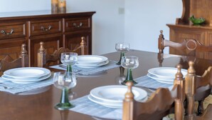 Mesa de jantar posta com pratos, copos e um jogo americano.