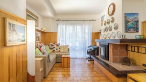 Una sala de estar acogedora con un sofá, una chimenea y un comedor.