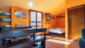 Una habitación con un banco de madera, una cama, un radiador y una puerta.