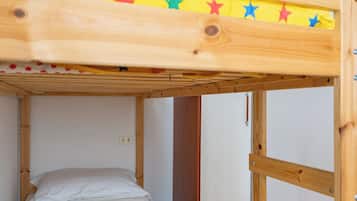 A bunk bed with a yellow and white quilt, a wooden frame, and a star decoration on the top bunk.