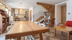 A spacious kitchen with a wooden dining table and chairs, a built-in oven, and a refrigerator. - Ballabio Lake - Rustic Chic Retreat (Ballabio)