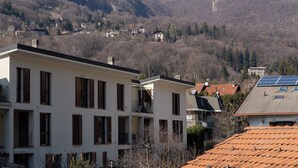 Un quartier résidentiel avec des bâtiments modernes, une chaîne de montagnes en arrière-plan et un ciel dégagé.