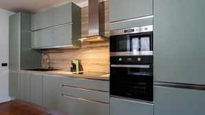 Une cuisine moderne dotée d’appareils électroménagers intégrés, notamment une cuisinière, un four et un four à micro-ondes.