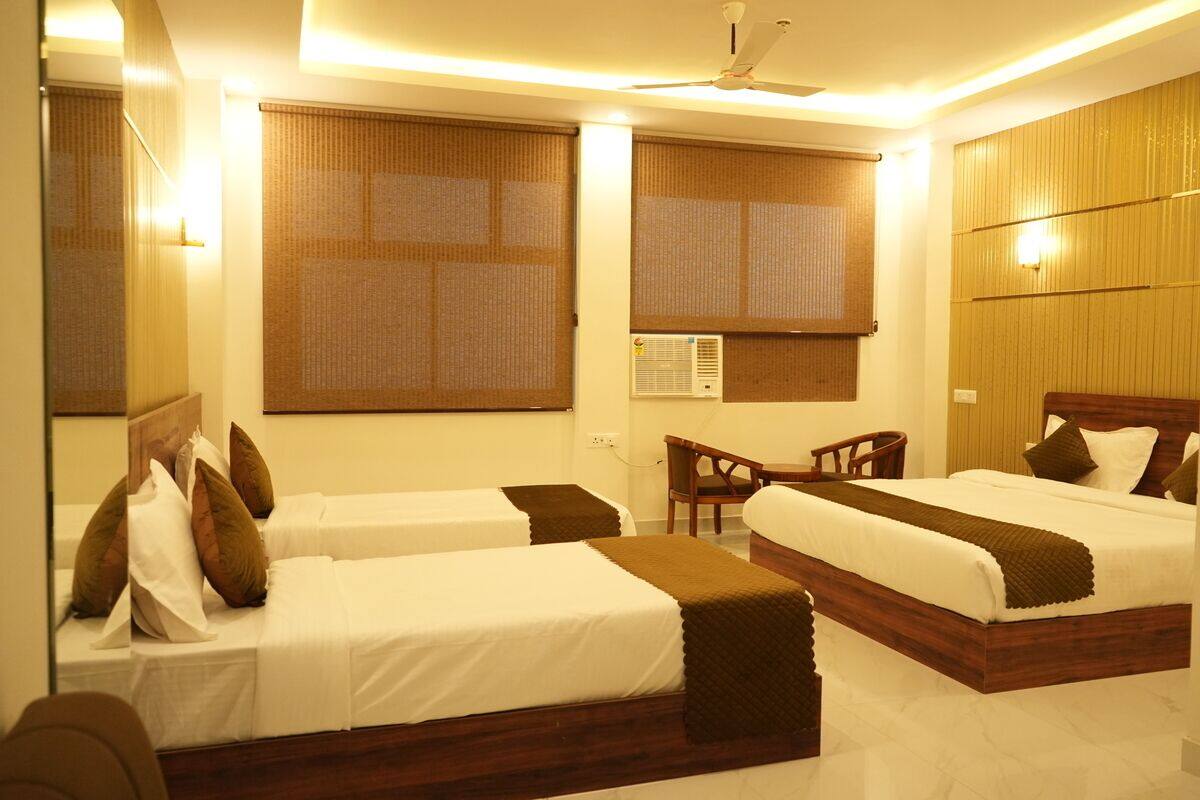A hotel room with two beds, a desk, and a chair.