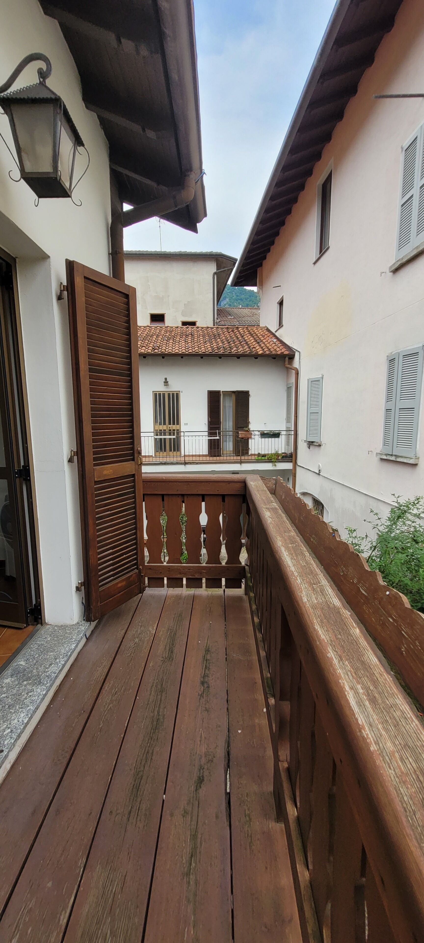 Un balcone in legno con vista sugli edifici vicini.