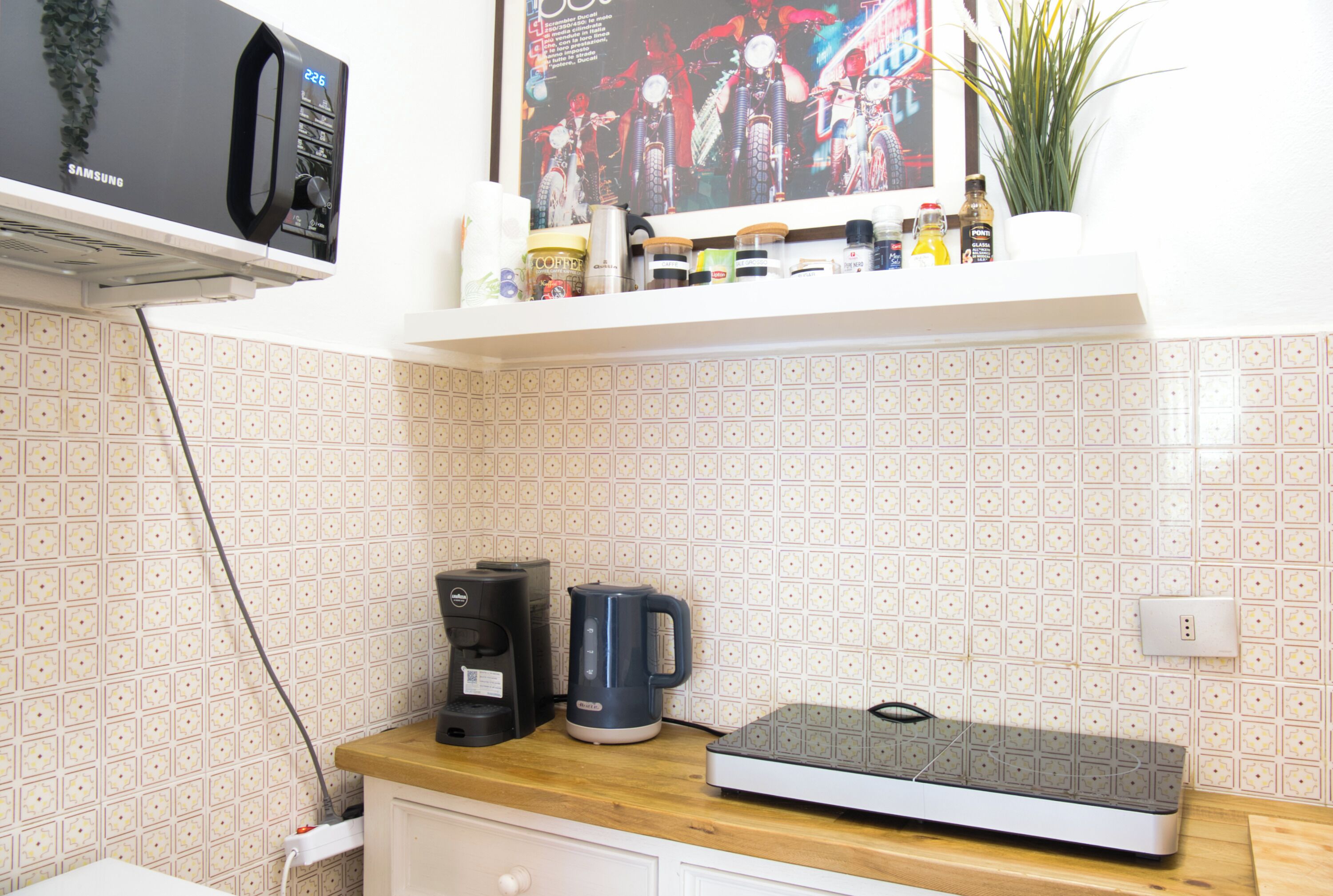 A kitchen with a microwave, coffee maker, and scale on the counter.