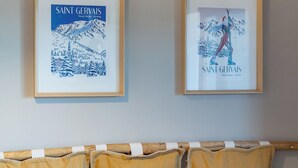 Ein Zimmer mit einer Holzbänke, einem Esstisch und zwei gerahmten Bildern von Saint Gervais.