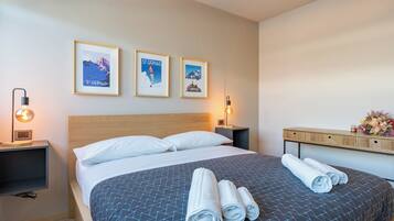 Ein Hotelzimmer mit einem Bett, zwei Nachttischen und drei gerahmten Bildern an der Wand.