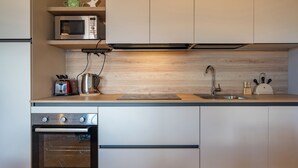 Eine moderne Küche mit integriertem Mikrowellenherd, Toaster, Wasserkocher und Backofen.