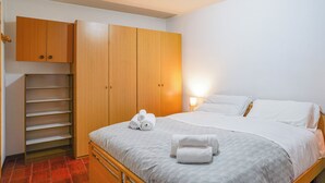 Ein Schlafzimmer mit einem Bett, einem Kleiderschrank und einem Regal.