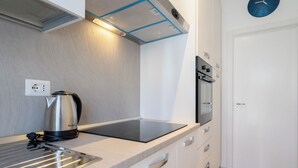 Una cocina moderna con horno empotrado, hervidor y encimera.
