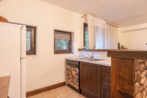 Kjøleskap, kokeplater, kjøkkenutstyr og spisebord