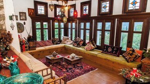A cozy room with a wooden bench, a patterned rug, and a table with a teapot. - 260m2 Unique Mountain House in Lilea Parnasos (Delphi)