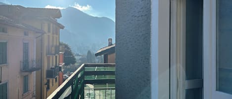A balcony with a view of a mountain and buildings.