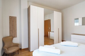 A modern bedroom with a bed, a chair, a wardrobe, and a mirror. - Lecco Isola - Top Apartment near Viscontea Island (Lecco)