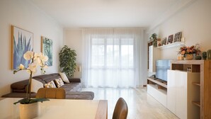 A modern living room with a sofa, a dining table, and a TV. - Lecco Isola - Top Apartment near Viscontea Island (Lecco)