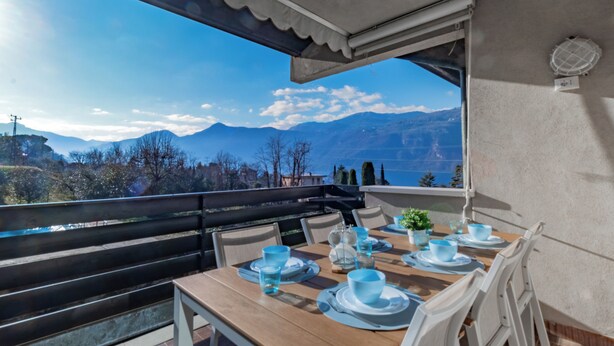 Un coin repas avec une table dressée pour deux personnes, donnant sur un paysage montagneux.