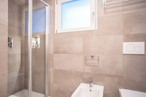 Een douche, een haardroger, een bidet, handdoeken