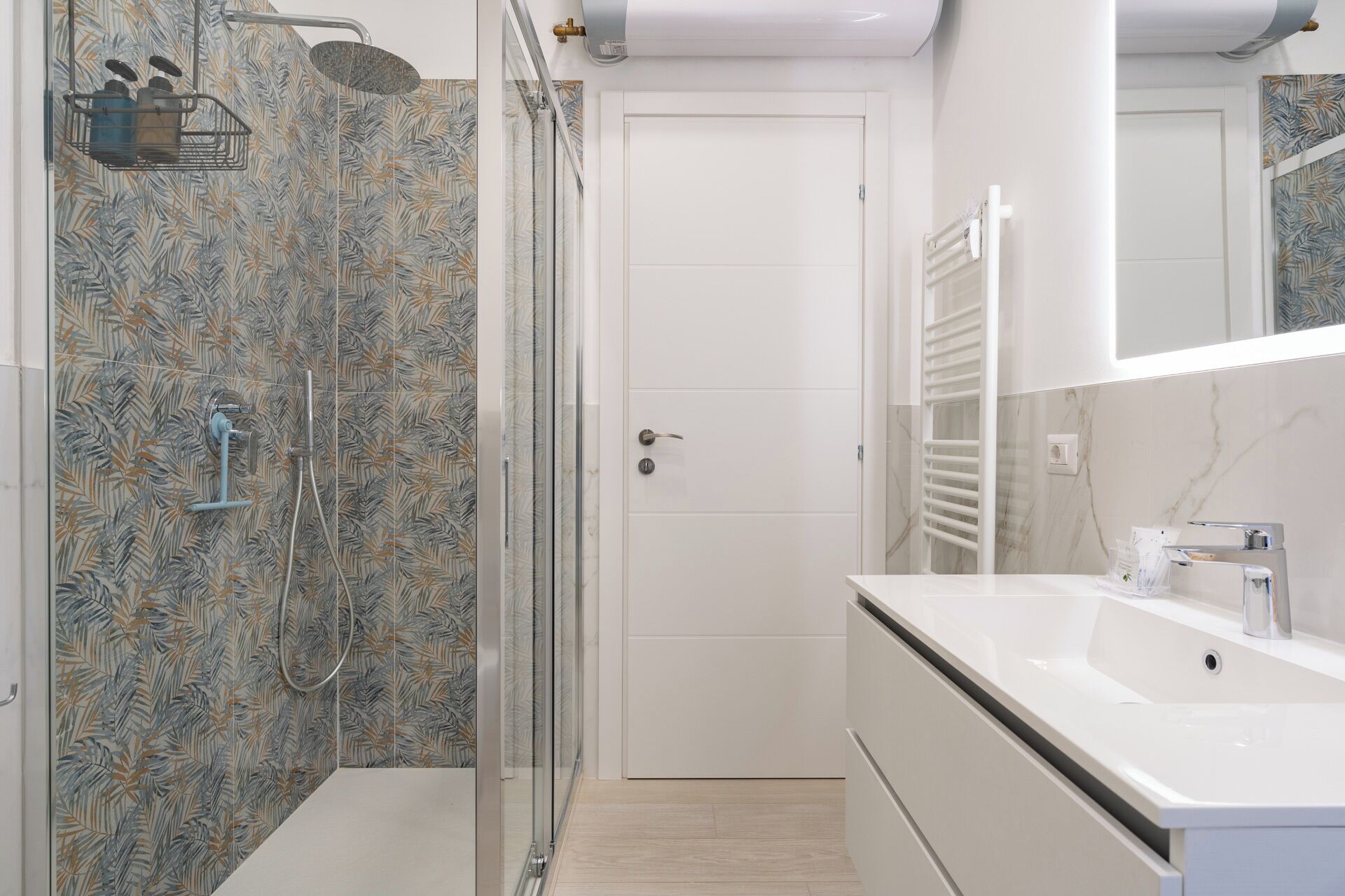 A modern bathroom with a shower, a sink, and a mirror.