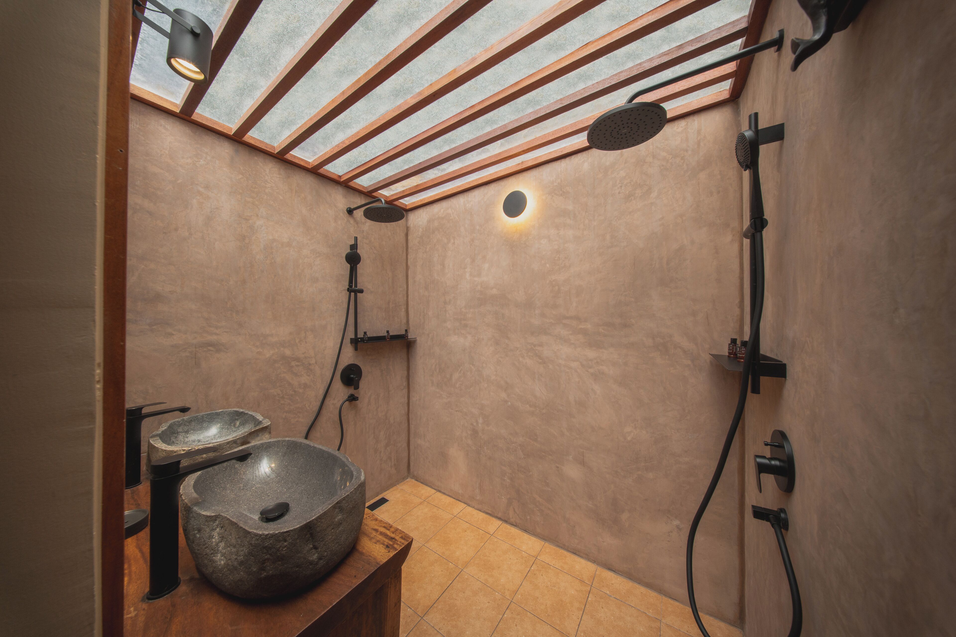 Ein modernes Badezimmer mit Oberlicht, einem großzügigen Steintonne und einer Duschzone.