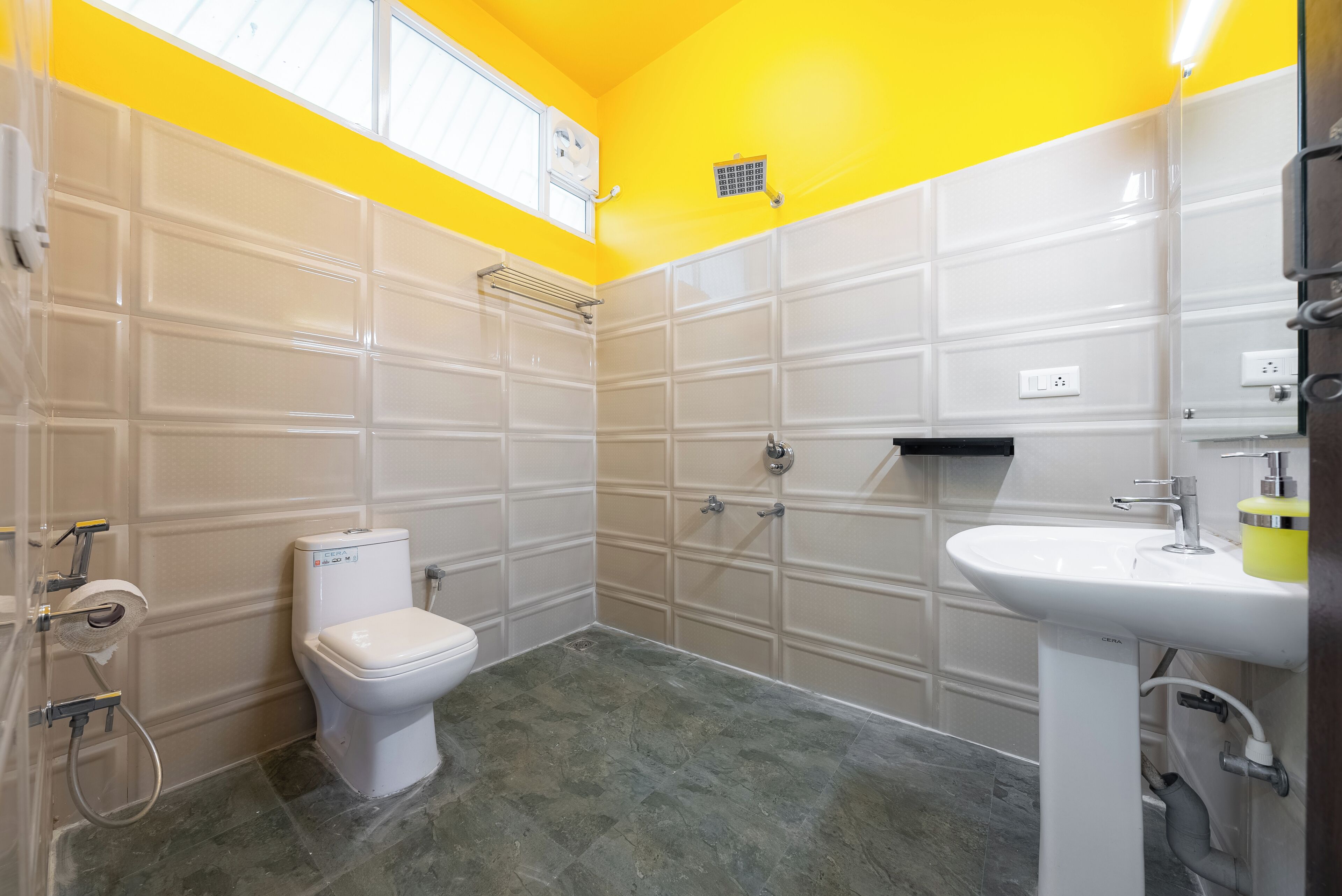 Een badkamer met een wit toilet, een wastafel en een douche.