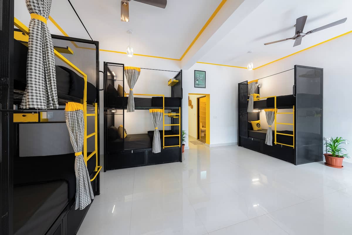 A modern hotel room with bunk beds, a ceiling fan, and a bright, clean design.