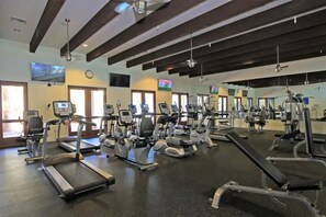 Ein Fitnessstudio mit Laufbändern, Crosstrainern und Kraftgeräten.