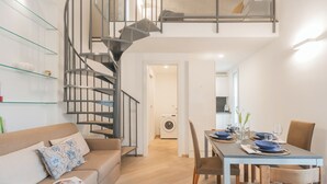 Un apartamento moderno con una escalera en espiral, un comedor y una lavandería.