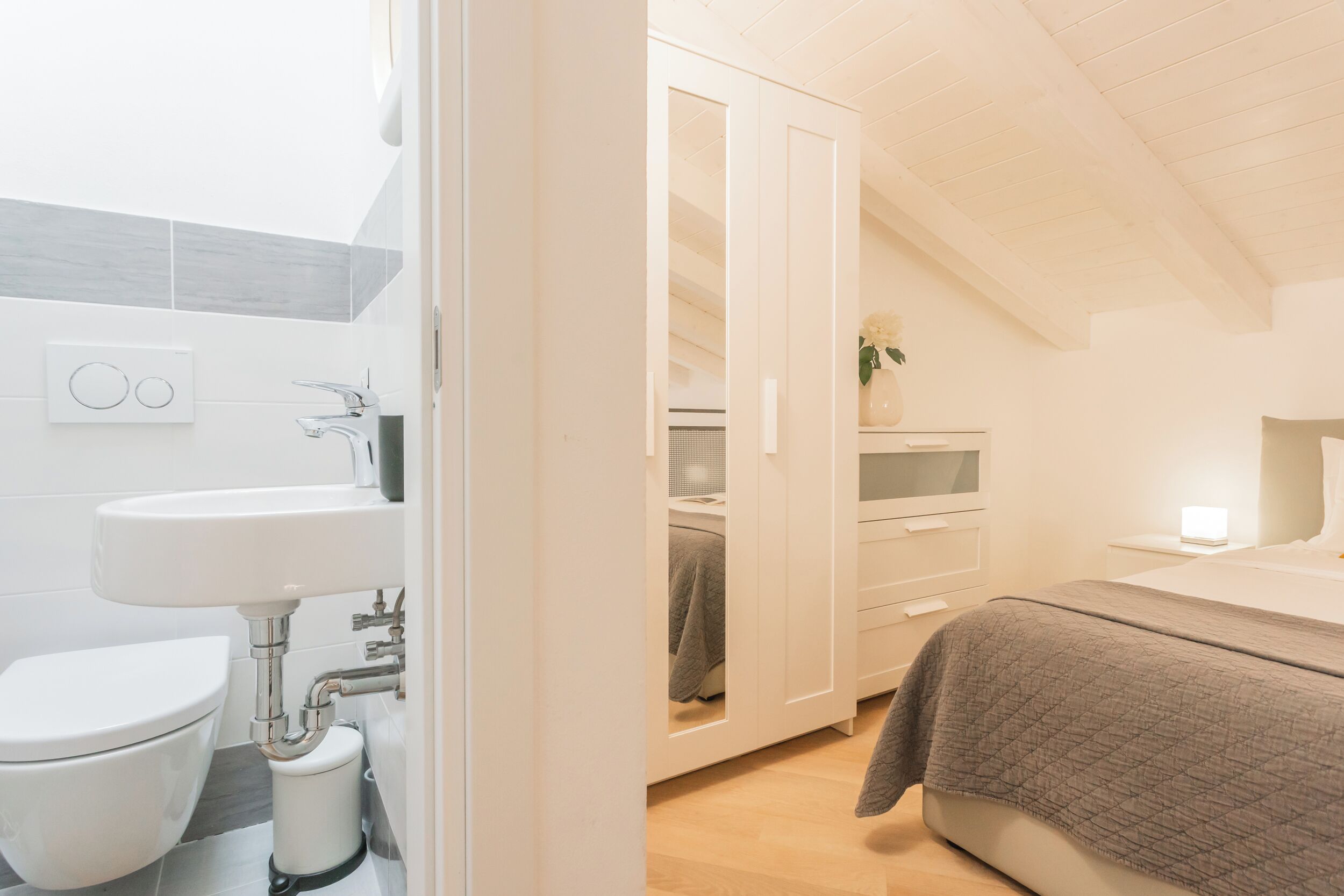 Una camera da letto moderna con un letto, un comodino e una abat-jour.