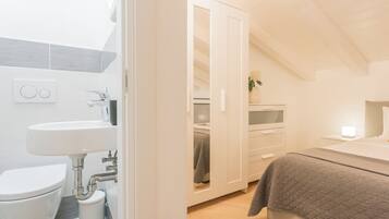 Una camera da letto moderna con un letto, un comodino e una abat-jour.
