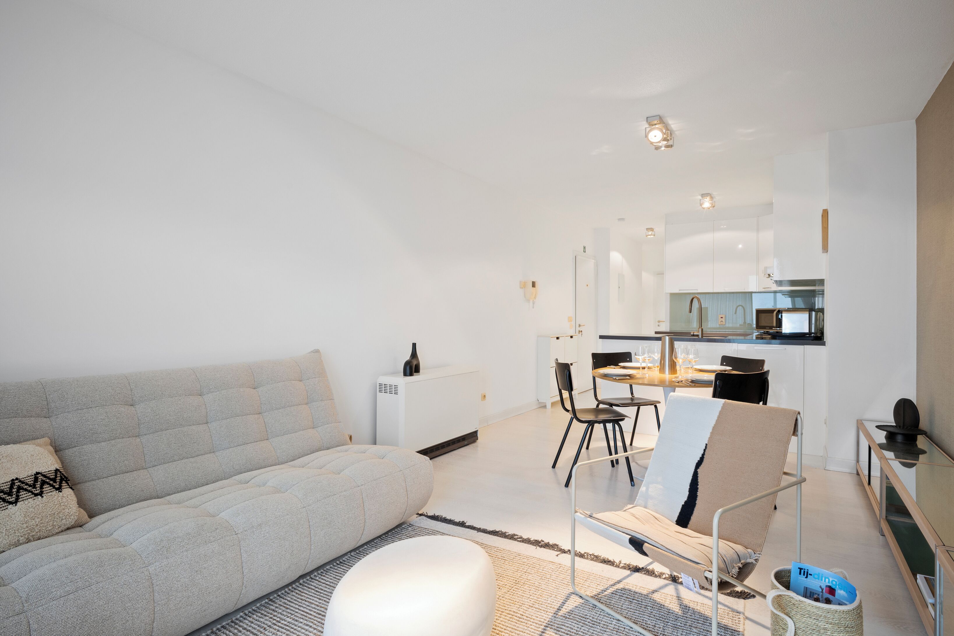 Ein modernes Wohnzimmer mit einer Couch, einem Couchtisch und einem Essbereich mit Stühlen und einem Tisch.