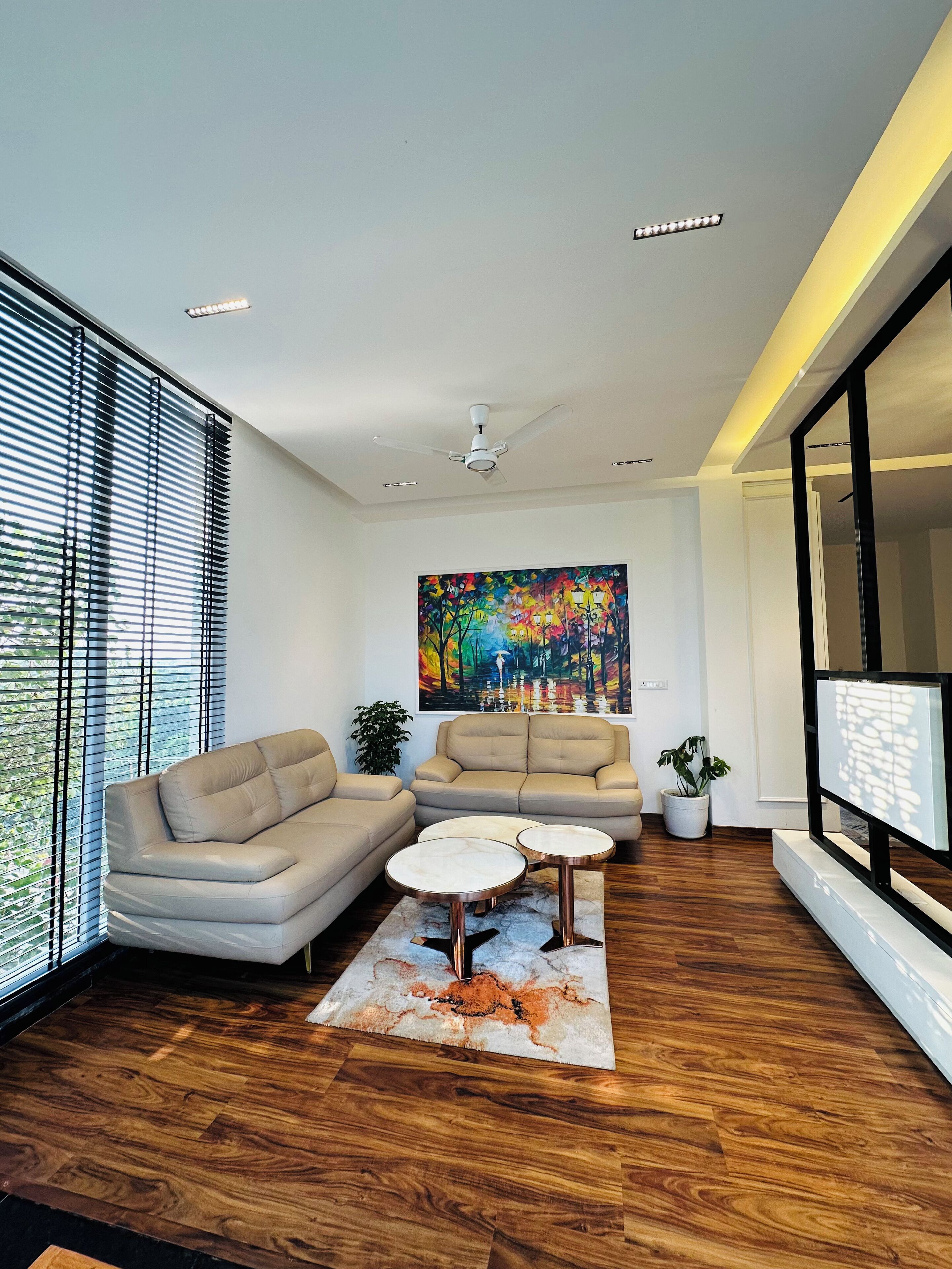 A modern living room with a sectional sofa, a coffee table, and a painting on the wall.