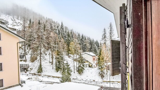 Un paysage enneigé avec un bâtiment et des arbres.