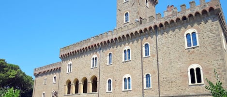 A large stone building with multiple arched windows and a central tower.