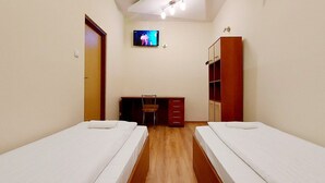A room with two single beds, a desk with a chair, a television, and a wardrobe. - Zajazd Panorama (Radymno)