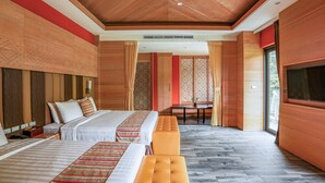 A hotel room with two beds, a bench, a dining table, and a TV. - Sunrise Hot Spring Hotel (Taian)