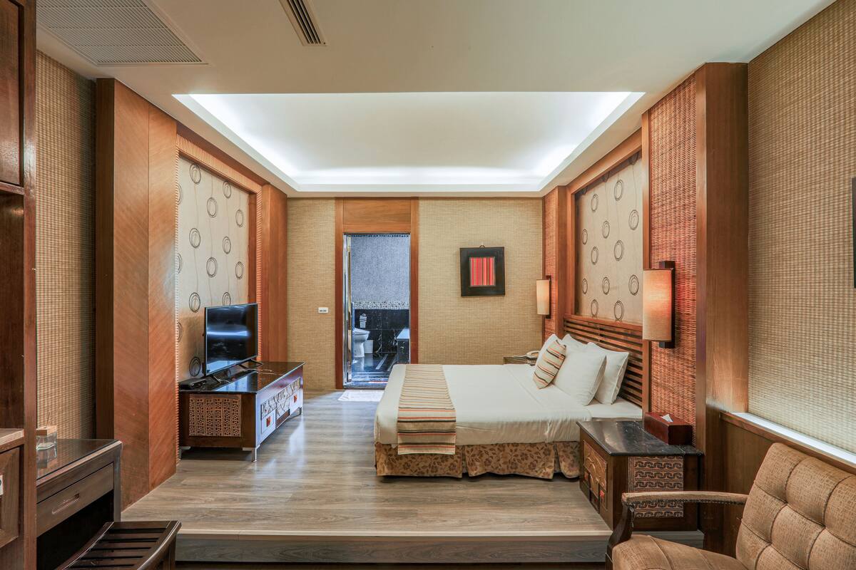Une chambre d’hôtel avec un lit, une télévision, un bureau et une chaise.