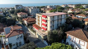 A residential area with a mix of single and multi-story buildings, featuring red-tiled roofs and balconies.