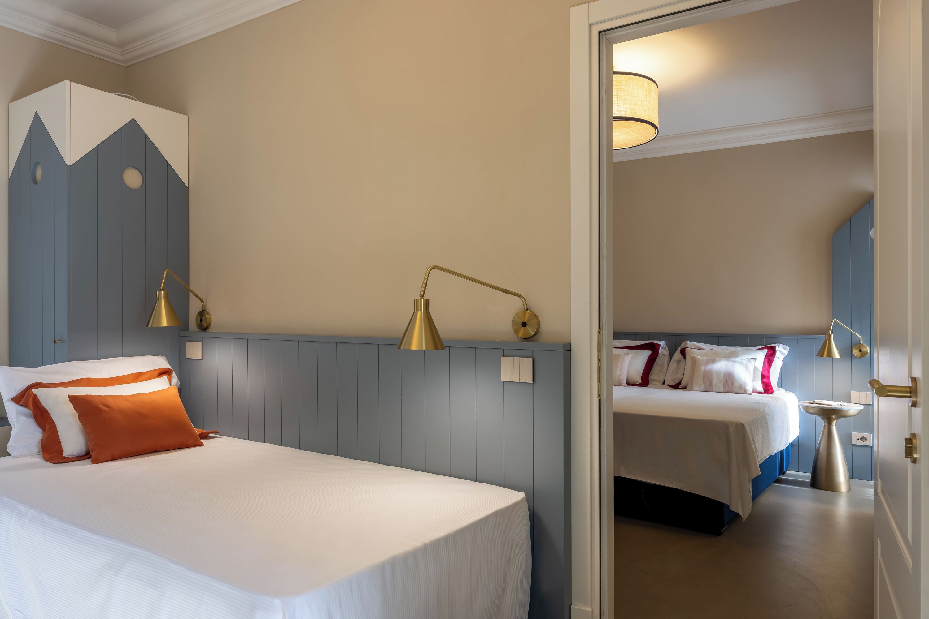 A hotel room with a bed, bedside tables, lamps, and a wardrobe.