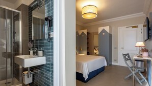 A modern bathroom with a glass shower enclosure, a white sink, and a mirror.