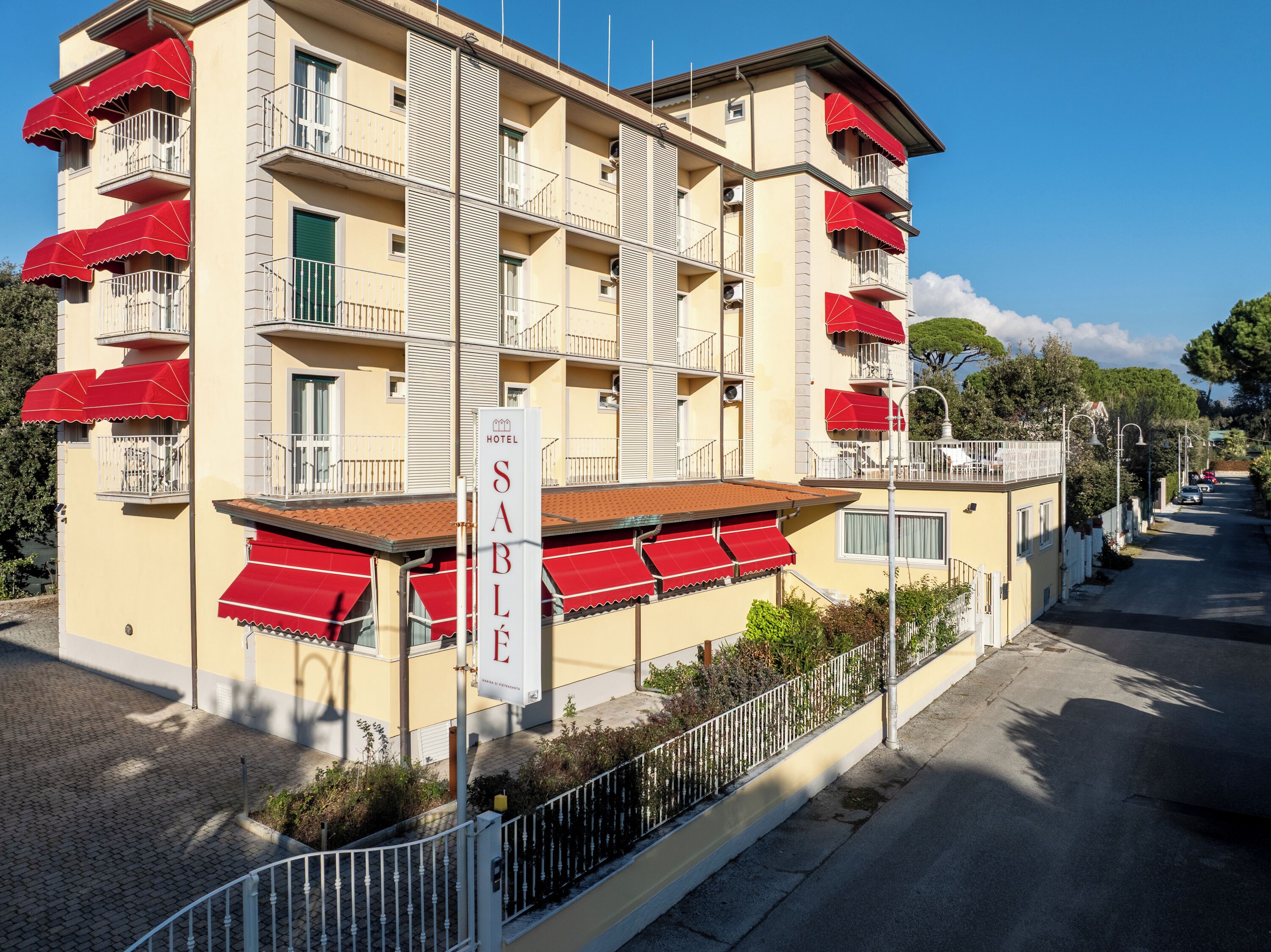 Un hôtel doté de nombreux balcons, de marquises rouges et d’une enseigne indiquant qu’il s’agit d’un hôtel.