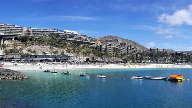 A coastal resort with a beach, clear blue waters, and a mountainous backdrop. - House in Puerto de Mogan With Marina Views (Mogan)